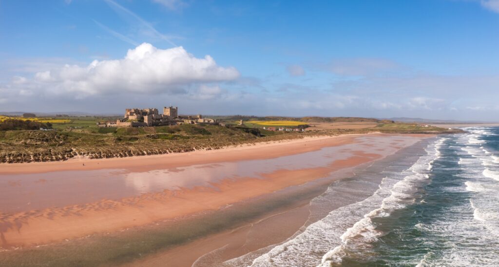 Aerial panorama landscape of Bamburgh village and beach on the Northumberland coast